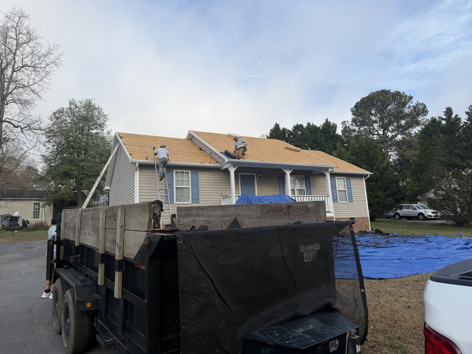 Ranch home with roof deck exposed during replacement, Serranos crew working