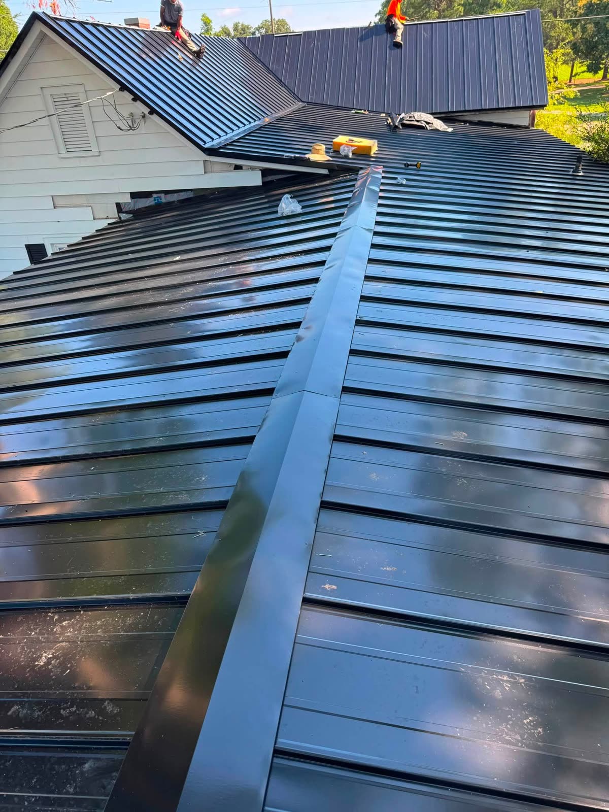 Serranos crew installing a black standing-seam metal roof